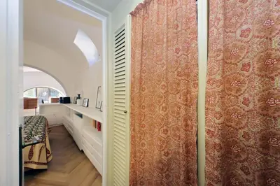 a room with a wall with a curtain and a table at Pantheon Apartment with private terrace in Rome