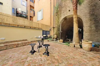 a patio with a table and two stools in front of a building at Pantheon Apartment with private terrace in Rome