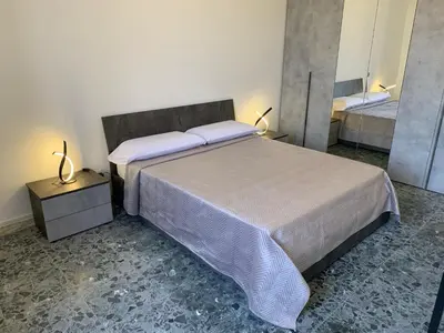 a bedroom with a large bed and a mirror at Tristar Terrace Penthouse in Rome