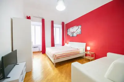 a red bedroom with a bed and a tv at Vatican Apartment - Sister's Place in Rome