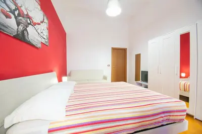 a bedroom with a large bed with a red wall at Vatican Apartment - Sister's Place in Rome