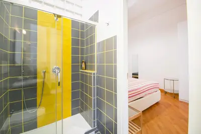 a bathroom with a shower with yellow and blue tiles at Vatican Apartment - Sister's Place in Rome