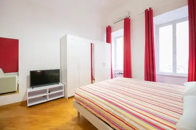 a bedroom with a bed and a flat screen tv at Vatican Apartment - Sister's Place in Rome