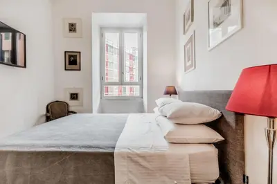 a white bedroom with a large bed with pillows at Casa Caracciolo Roma Vaticano in Rome