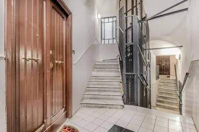 a staircase in a home with a wooden door at Casa Caracciolo Roma Vaticano in Rome