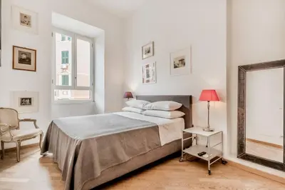 a bedroom with a bed and a chair and a mirror at Casa Caracciolo Roma Vaticano in Rome