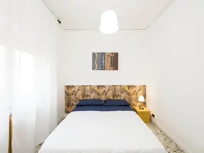 a bedroom with a white bed and a yellow table at Blessy apartment Vaticano in Rome