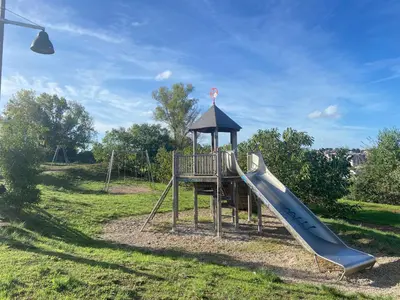 a playground with a slide in a field at Blessy apartment Vaticano in Rome