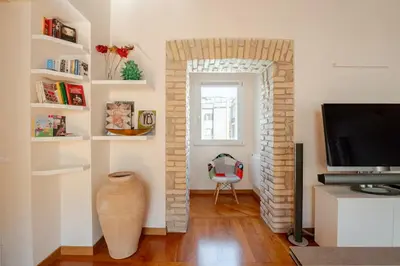 a living room with a brick fireplace and a television at Via Umbria 25 Luxury Suites in Rome