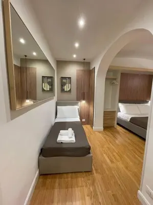 a room with a bed with a mirror and two beds at Elian Apartament In The Center of Rome #2 in Rome
