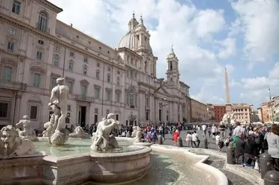 a crowd of people standing around a fountain in front of a building at Parione Suite Piazza Navona in Rome