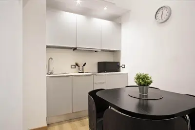 a kitchen and dining room with a table and a clock at Navona Comfort House in Rome