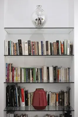 a book shelf filled with books with a red lamp at Navona Comfort House in Rome