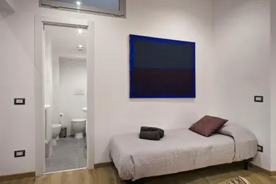 a white room with a bed and a bathroom at Navona Comfort House in Rome