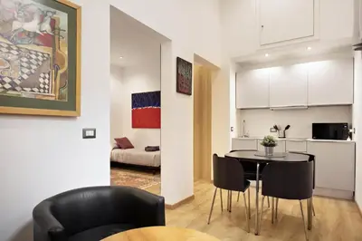 a kitchen and a dining room with a table and chairs at Navona Comfort House in Rome