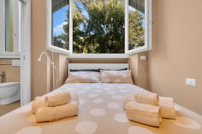 a bedroom with a large bed with two windows at CASA REMO - for family, 2 bathrooms, AC, self check-in in Rome