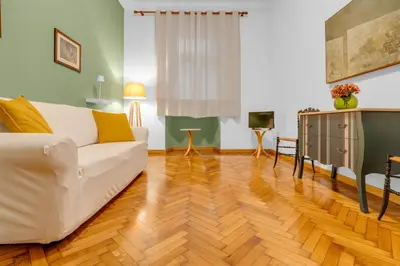 a living room with a white couch and a wooden floor at CASA REMO - for family, 2 bathrooms, AC, self check-in in Rome