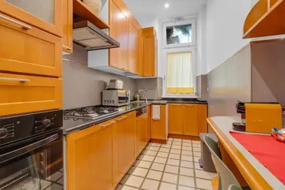a kitchen with wooden cabinets and a stove top oven at CASA REMO - for family, 2 bathrooms, AC, self check-in in Rome