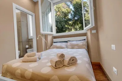 a bedroom with a bed with towels and a window at CASA REMO - for family, 2 bathrooms, AC, self check-in in Rome