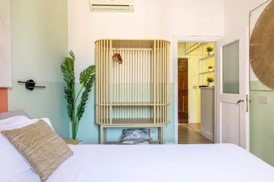 a bedroom with a white bed and a plant at Milo Apt - Trastevere's Gem in Rome