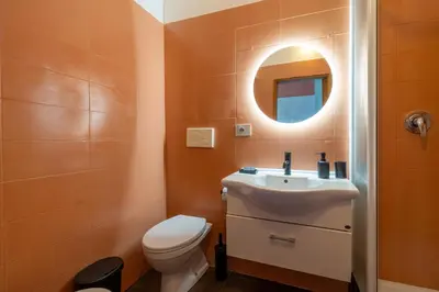 a bathroom with a toilet and a sink and a mirror at Milo Apt - Trastevere's Gem in Rome