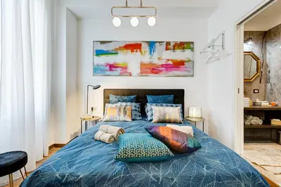a bedroom with a blue bed with pillows at Roma in Relax Lovely Loft in the center of Rome Fabrizia in Rome