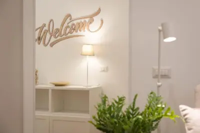 a welcome sign on a wall in a room at Colosseum Holidays - Three-Bedroom Apartment in Rome