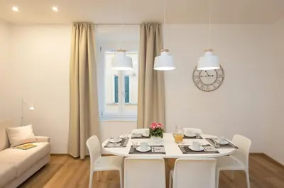 a white table and chairs in a living room at Colosseum Holidays - Three-Bedroom Apartment in Rome