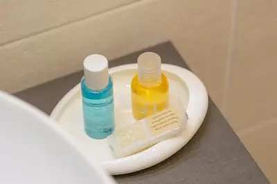 a bathroom sink with two bottles of mouthwash and a toothbrush at Colosseum Holidays - Three-Bedroom Apartment in Rome