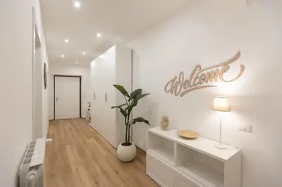 a white hallway with a sign on the wall at Colosseum Holidays - Three-Bedroom Apartment in Rome