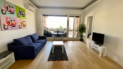 a living room with a blue couch and a tv at Moderno bilocale con terrazzo in Rome