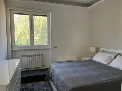 a white bedroom with a bed and a window at Moderno bilocale con terrazzo in Rome