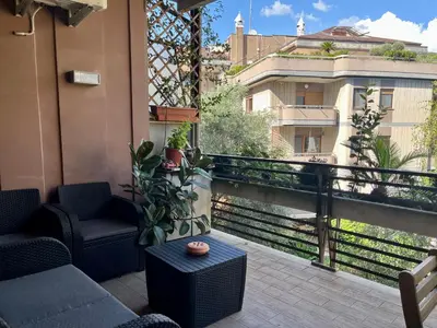 a balcony with a couch and a table and a view at Moderno bilocale con terrazzo in Rome