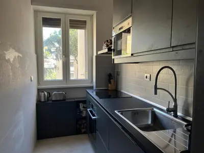 a kitchen with black counters and a sink and a window at Moderno bilocale con terrazzo in Rome