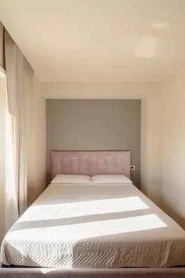 a bedroom with a large bed with white sheets at Saint Peter Vatican luxury apartment in Rome