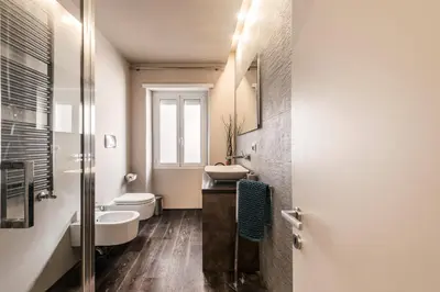 a bathroom with a sink and a toilet and a mirror at Saint Peter Vatican luxury apartment in Rome
