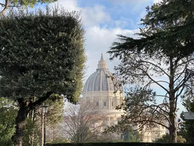 a building with a dome in the background with trees at Casa Blu Testaccio in Rome