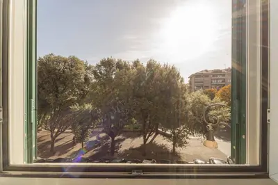 a window with a view of a park with trees at Casa Blu Testaccio in Rome
