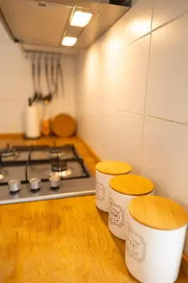 a kitchen with a stove and two stools at Porto Fluviale Penthouse - Rome Collection in Rome