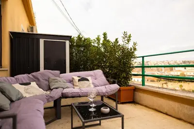 a balcony with a purple couch and a table at Porto Fluviale Penthouse - Rome Collection in Rome
