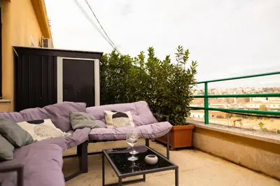 a balcony with a purple couch and a table at Porto Fluviale Penthouse - Rome Collection in Rome