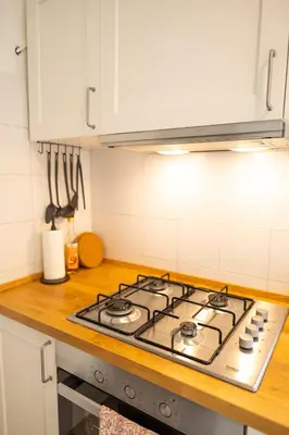 a stove top in a kitchen with white cabinets at Porto Fluviale Penthouse - Rome Collection in Rome