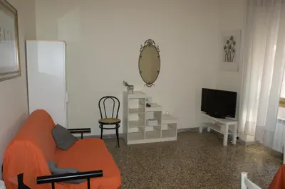 a living room with an orange couch and a television at Nido Vidaschi in Rome