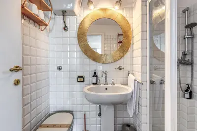 a white bathroom with a sink and a mirror at Terrazza Ippocrate in Rome
