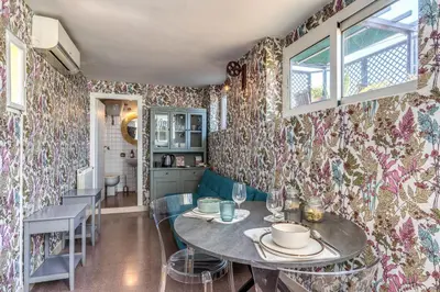 a dining room with floral wallpaper and a table and chairs at Terrazza Ippocrate in Rome