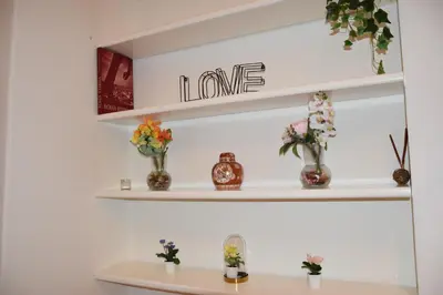 a shelf above a desk with flowers on it at Carla Luxury House in Rome