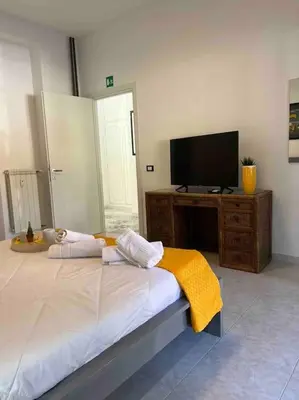 a bedroom with a bed and a flat screen tv at 3 FERMATE DAL COLOSSEO - Casa Vacanze Elena - 50 m da METRO GARBATELLA in Rome
