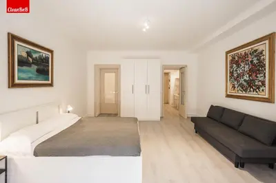 a white bedroom with a bed and a couch at GuestHost - La finestra sui palazzi di Roma Apartment in Rome