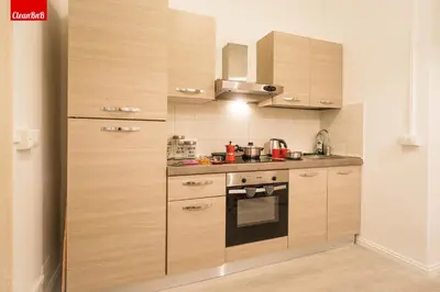 a kitchen with wooden cabinets and a stove at GuestHost - La finestra sui palazzi di Roma Apartment in Rome