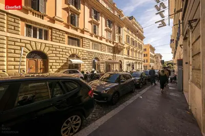 a street with cars parked on the side of a building at GuestHost - La finestra sui palazzi di Roma Apartment in Rome
